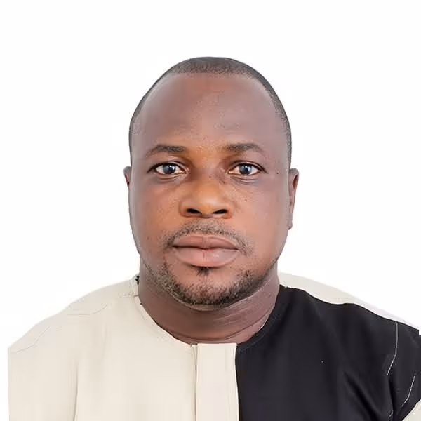Portrait of a man wearing a beige and black split-colored shirt against a white background.